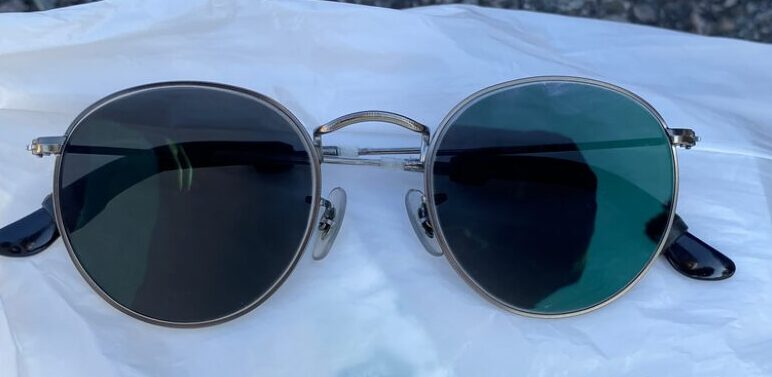 可視光調光レンズの暗くなったレンズを白い背景に置いた画像